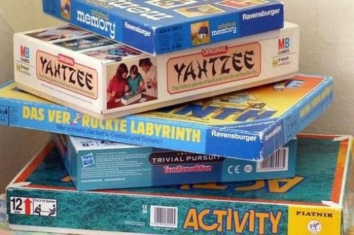 Verschiedene Gesellschaftsspiele liegen auf einem Stapel übereinander.